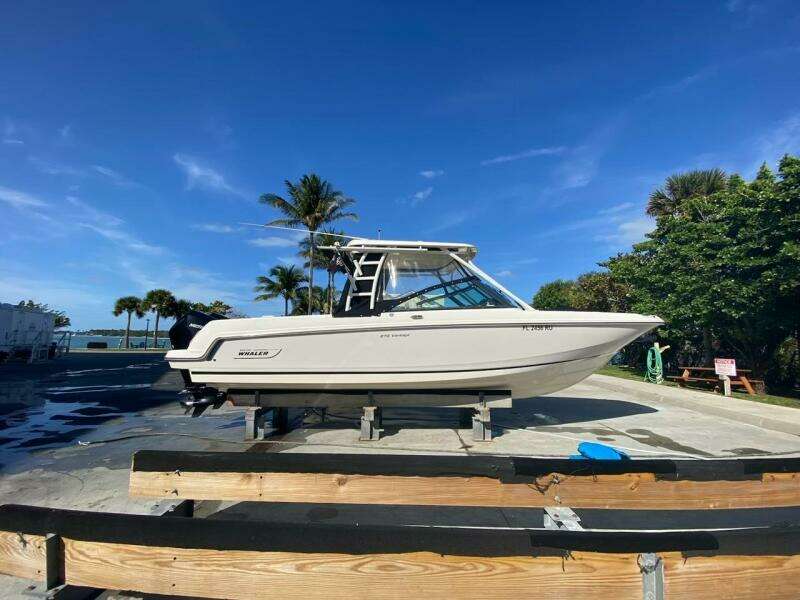 2018 Boston Whaler 270 Vantage boat on a dock with palm trees in the background.