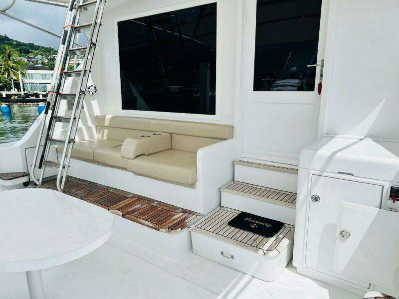 1988 Bertram 54' yacht deck with seating, ladder, and steps in a marina setting.