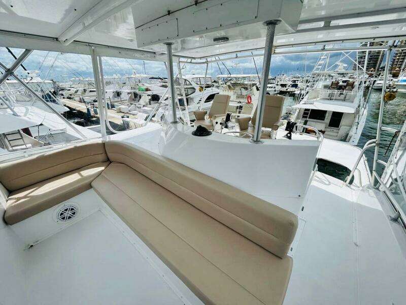 1988 Bertram 54' yacht interior with seating, docked among other boats.