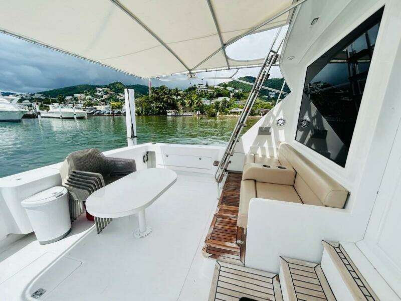 1988 Bertram 54' yacht deck with seating, table, and scenic marina view.