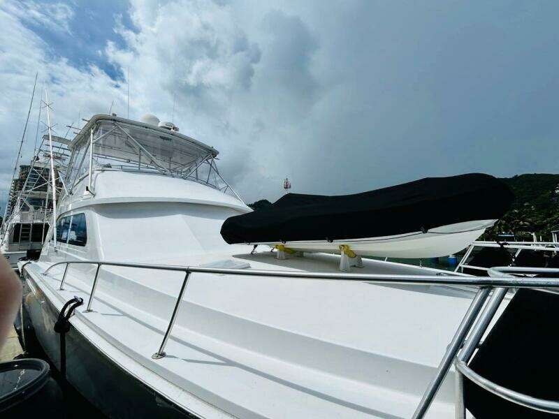 1988 Bertram 54' yacht docked under cloudy sky.