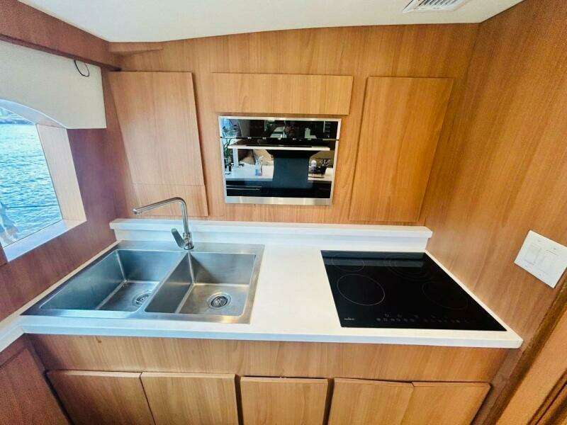 1988 Bertram 54' yacht kitchen with dual sink and electric cooktop.