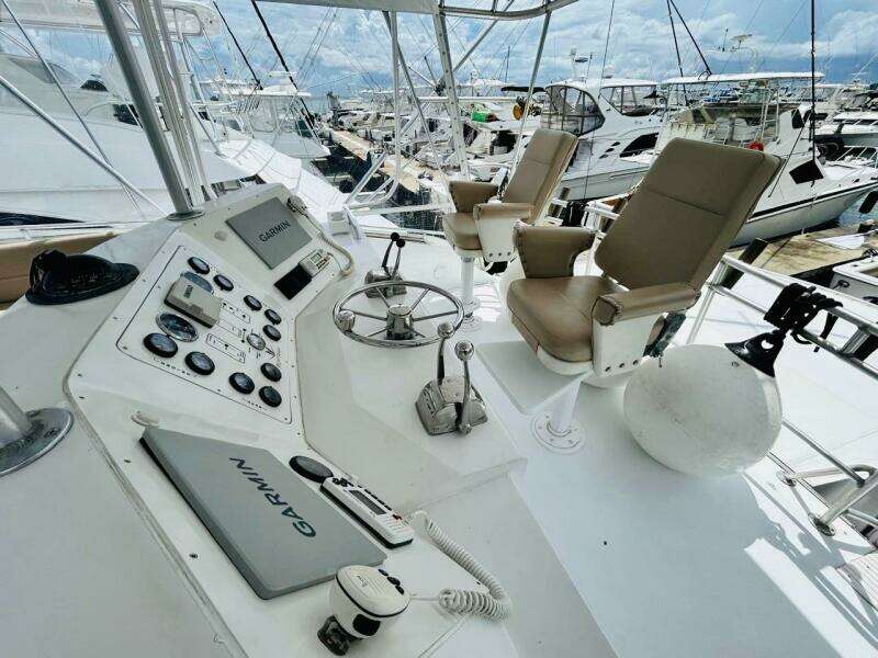 Cockpit of 1988 Bertram 54' yacht with Garmin navigation, docked at marina.