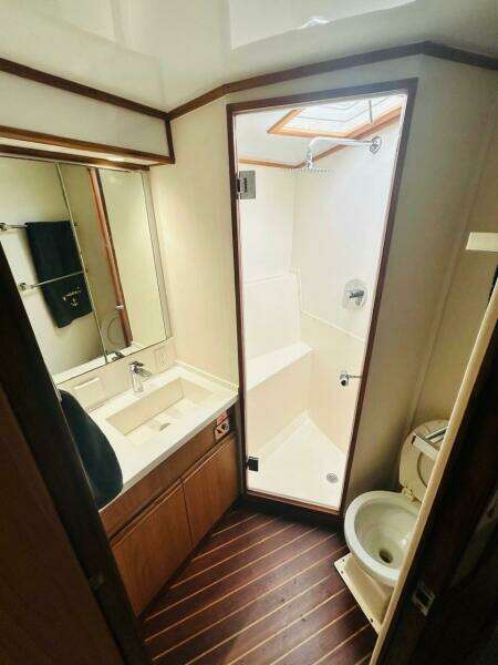 1988 Bertram 54' yacht bathroom with shower, sink, and toilet.