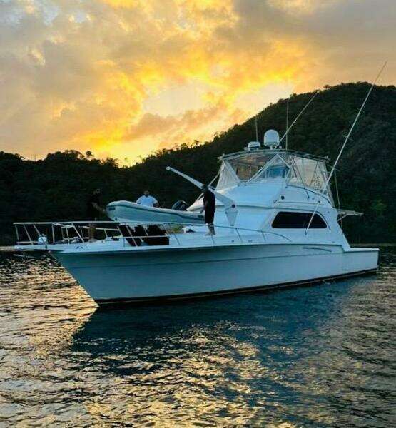 1988 Bertram 54' yacht at sunset on tranquil waters.