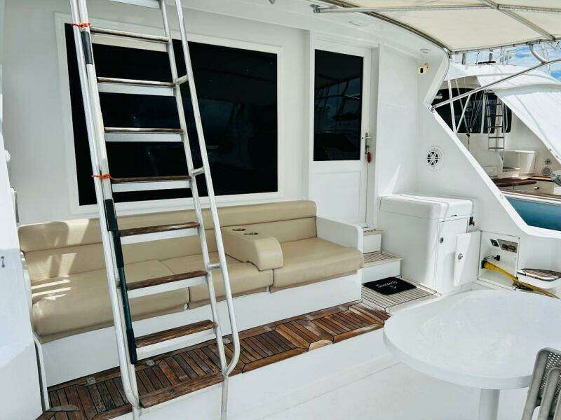 1988 Bertram 54' yacht deck with seating, ladder, and table.
