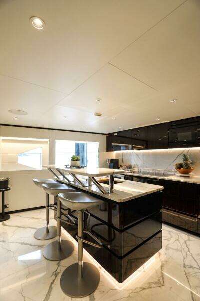 Luxurious 2025 Majesty 120 yacht interior with modern kitchen and sleek marble flooring.