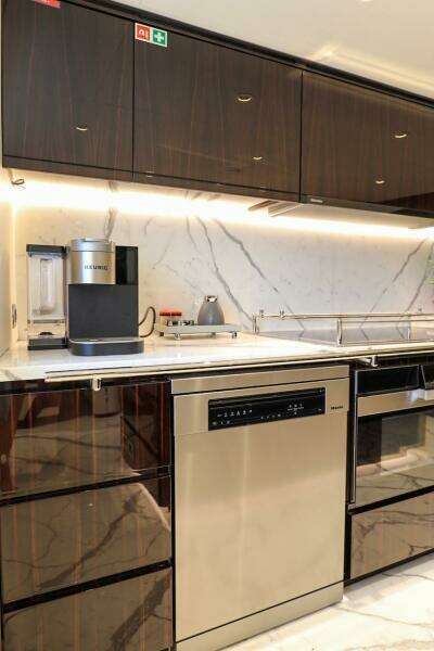 Modern kitchen with marble backsplash, sleek cabinetry, and high-end appliances on a Majesty 120 yacht.