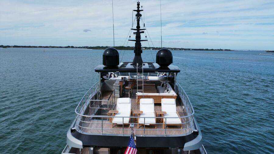Majesty 120 yacht, 2025 model, cruising on open water with deck chairs and American flag.