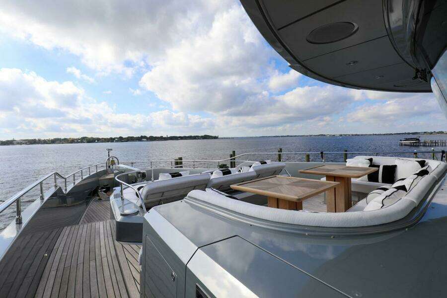 Luxurious 2025 Majesty 120 yacht deck with seating, overlooking serene waters and cloudy sky.