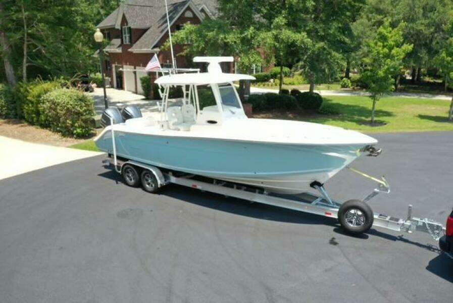 2021 Cobia 301 Center Console boat on trailer in residential driveway.