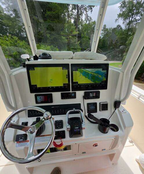 2021 Cobia 301 Center Console boat dashboard with dual navigation screens and steering wheel.