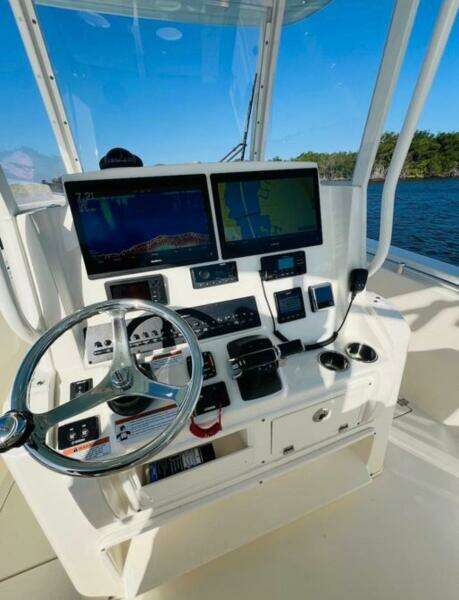 2021 Cobia 301 Center Console boat dashboard with dual screens and steering wheel.