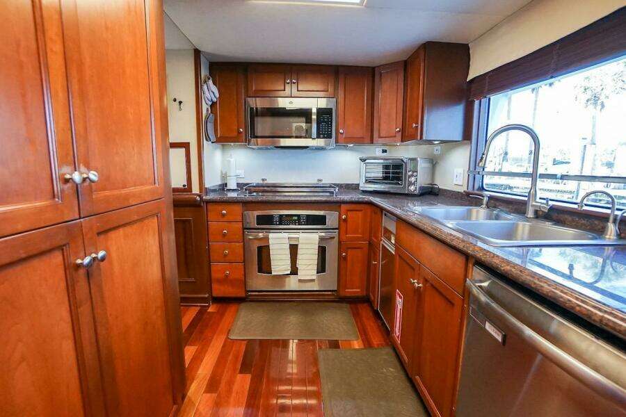 Luxurious kitchen in 1996 ABD 90 Explorer yacht with wooden cabinets and modern appliances.
