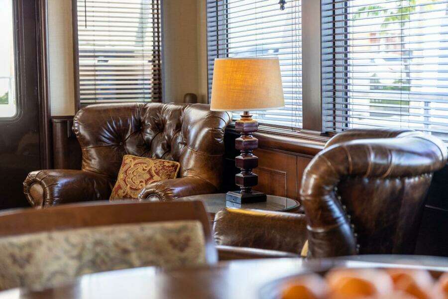 Office setup with Dell monitor, ergonomic chair, and orange cushion on a wooden desk.