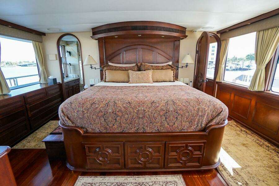 Luxurious bedroom interior on 1996 ABD 90 Explorer yacht with elegant wood finishes.