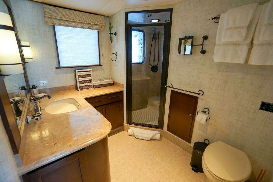 Luxurious 1996 ABD 90 Explorer yacht bathroom with marble countertop and glass shower.