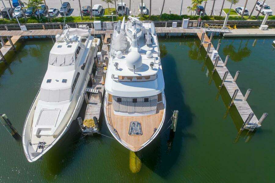 Two luxury yachts docked at a marina, featuring the 1996 ABD 90 Explorer.