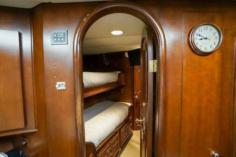 Interior of 1996 ABD 90 Explorer yacht with wooden bunk beds and clock.