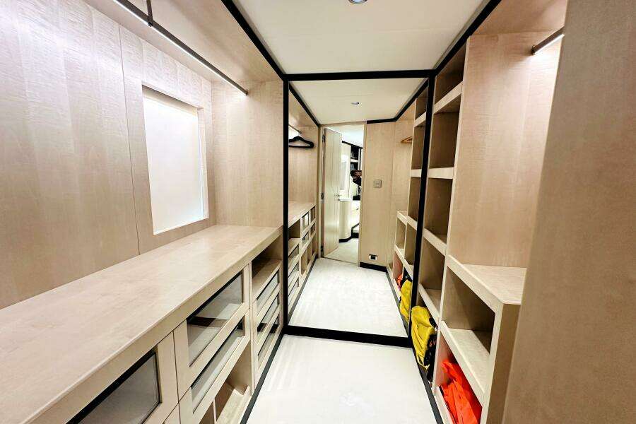 Luxurious walk-in closet on 2023 Majesty 120 yacht, featuring ample shelving and modern design.