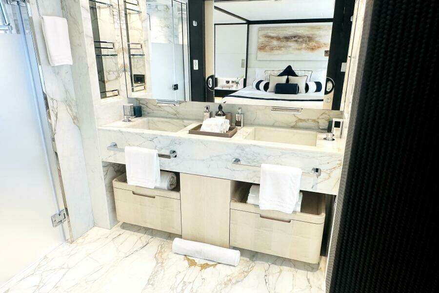Luxurious marble bathroom in 2023 Majesty 120 yacht, featuring dual sinks and elegant decor.
