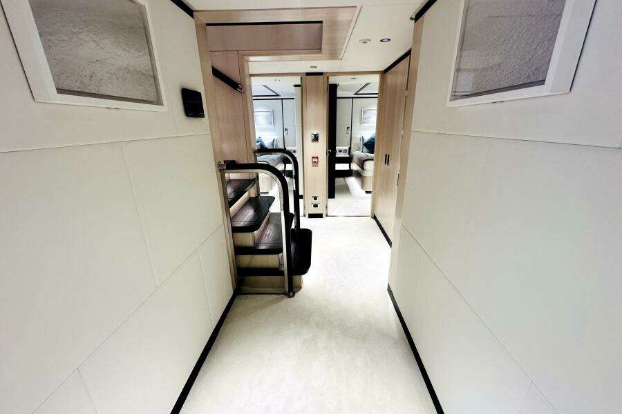 Luxurious interior hallway of 2023 Majesty 120 yacht with modern design and staircase.