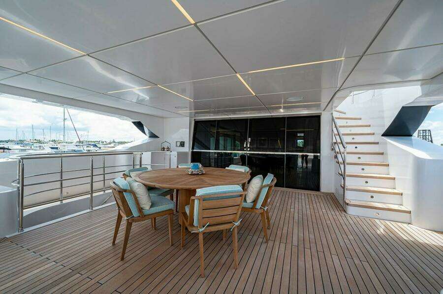 Spacious deck of 2020 Majesty 140 yacht with wooden furniture and modern design.